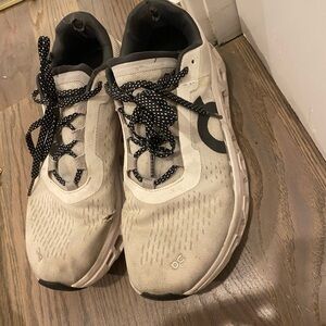 On Running Cream and Black Athletic Shoes